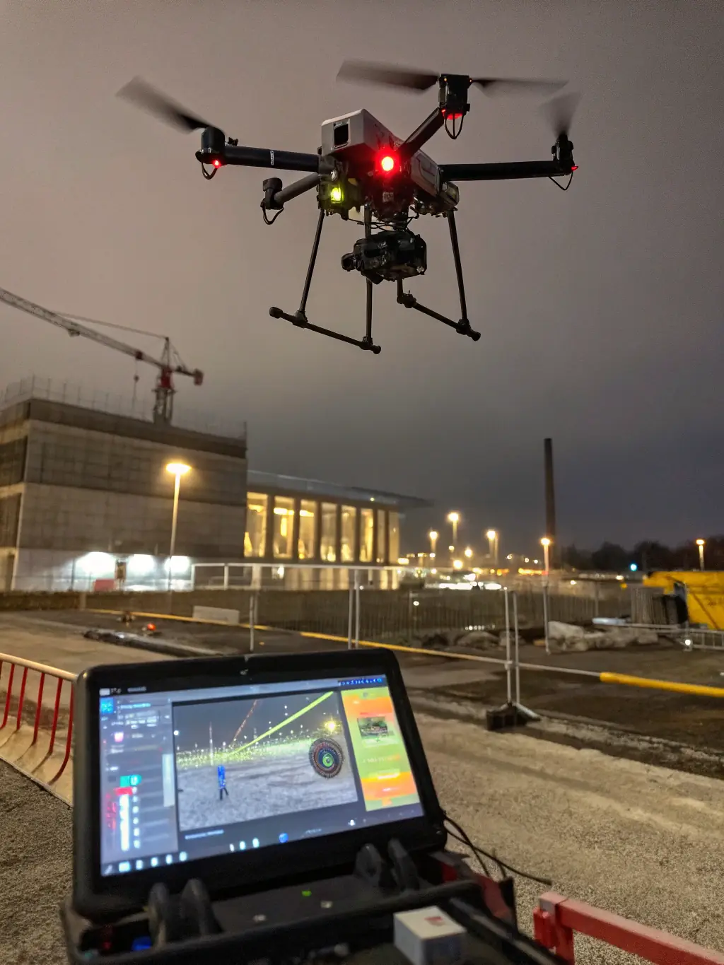 A drone equipped with various sensors flying over a construction site, capturing data for mapping, thermal analysis, and progress monitoring, used by Amped Aerial.