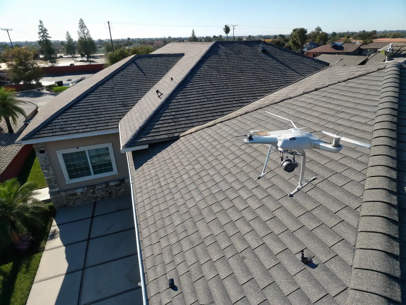 A drone conducting a thermal inspection of a building's roof, highlighting areas of heat loss with thermal imaging.